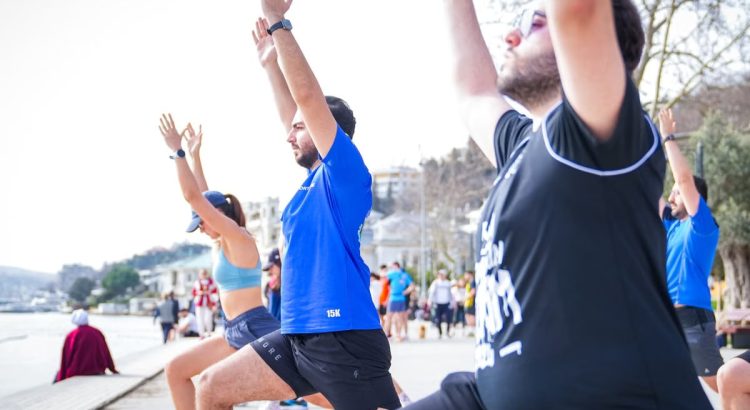 Group performing yoga outdoors along the scenic waterfront in İstanbul, Türkiye.